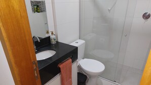 Un bagno con lavandino, WC e cabina doccia in vetro.