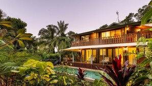 A two-story house with a balcony, surrounded by lush tropical vegetation and a swimming pool. - Papillon on Coral Sea - Have you ever imagined yourself in a treehouse? (Mossman Gorge)