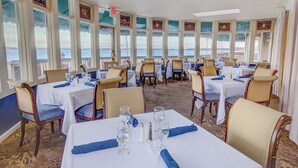 A restaurant with tables set for dining, large windows with views, and a carpeted floor. - 1 Bedroom Suite w/ Kitchenette, Sleeps 4, 10 min from Newport, at Voyager Inn! (Jamestown)