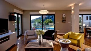 A modern living room with a large window, a pool view, and a dining area. - 4 bedroom nice home in Razanj (Razanj)