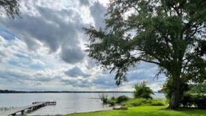 A grassy area with a picnic table and a fire pit, overlooking a body of water and a dock. - "Lost Crab", beautiful 3BR, big yard, private dock (Centre)