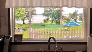 A window with a view of a grassy area, a bench, and a body of water. - "Lost Crab", beautiful 3BR, big yard, private dock (Centre)