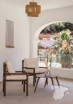 A modern living room with a large window, a woven light fixture, and a round coffee table. - CostaBlancaDreams - The Jave in Javea (Javea)