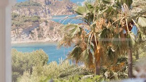 A view from a balcony overlooking a coastal landscape with palm trees and a rocky shoreline. - CostaBlancaDreams - The Jave in Javea (Javea)