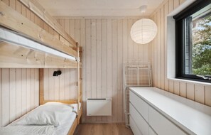 Cozy retreat with a bunk bed, radiator, and window offering a view of the outdoors.