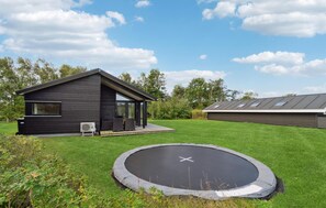 Guests can enjoy a spacious porch and a well-maintained lawn with a trampoline.