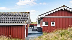 A red building with a tiled roof and a small outdoor seating area.