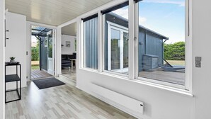 Ein modernes Interieur mit großen Schiebegläsern, die auf eine Terrasse im Freien führen.