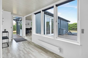 Un intérieur moderne avec de grandes portes-fenêtres coulissantes donnant sur une terrasse extérieure.
