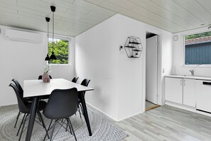 Eine moderne Küche mit weißen Schränken, einem eingebauten Geschirrspüler und einem Fenster mit Blick auf Grünflächen.