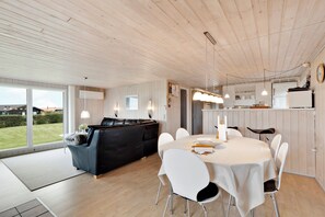 A modern interior with a dining area, a sofa, and a view of the outdoors. - Fantastic view over Venø bay (Vinderup)