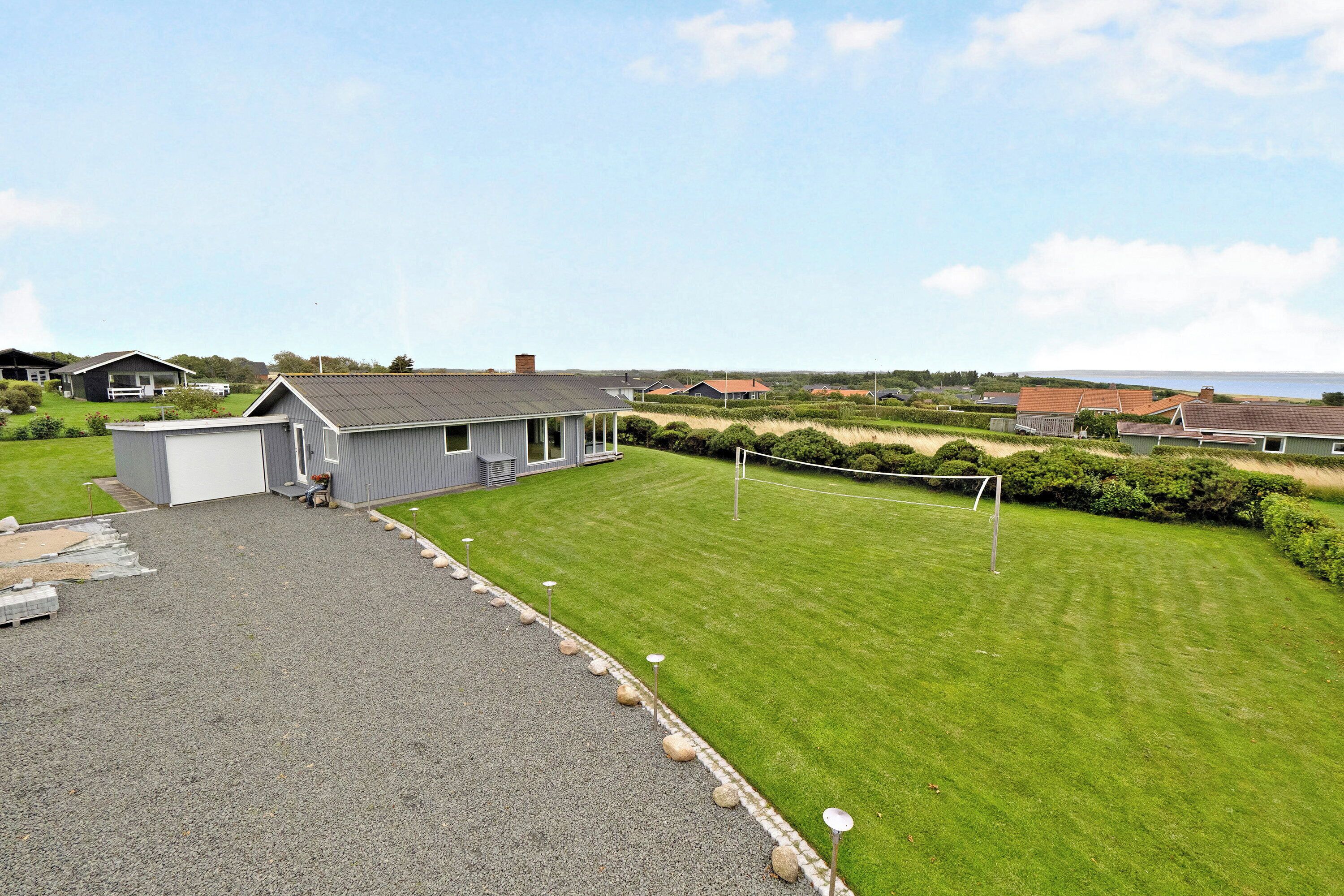 A residential area with a well-maintained lawn, a gravel driveway, and a small shed.