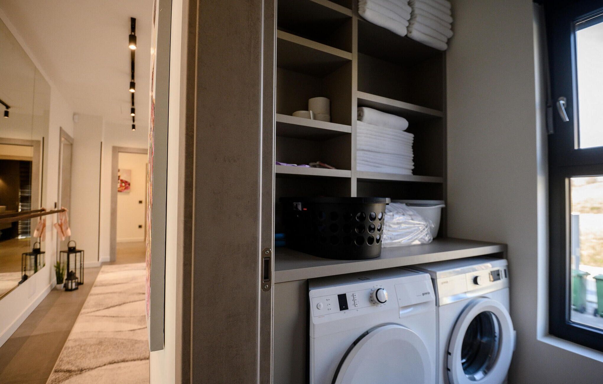 A laundry room with stacked towels, a washing machine, and a dryer.