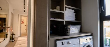 A laundry room with stacked towels, a washing machine, and a dryer.