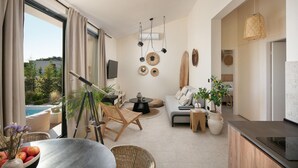 Un soggiorno moderno con vista mare, un'area pranzo con tavolo e sedie, e un angolo cottura con un piano cottura.
