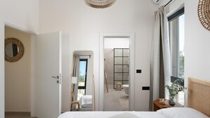 Una camera d'albergo con un letto, uno specchio, una finestra con tende, un angolo doccia e vista sull'esterno.