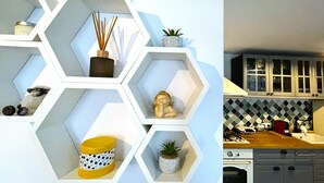Una cocina con gabinetes blancos, salpicadero de azulejos y encimera de madera.