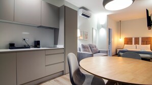 Une cuisine moderne avec une table de salle à manger ronde, des chaises grises et un four encastré.
