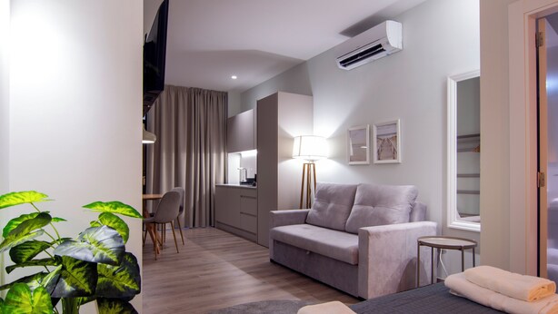 Une chambre d’hôtel moderne équipée d’un lit, d’un canapé, d’un bureau et d’une chaise.