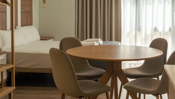 A hotel room with a bed, a round wooden table, and four chairs. - VLC HOST - Reino 6 (Valencia)