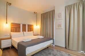 A neatly made bed with a wooden headboard, two bedside tables, and a large window with curtains. - VLC HOST - Reino 7 (Valencia)