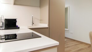 A modern kitchen with a white countertop, a black coffee machine, a sink, and a window. - VLC HOST - Reino 7 (Valencia)