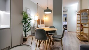 A modern dining area with a round table, grey chairs, and pendant lighting. - VLC HOST - Reino 5 (Valencia)
