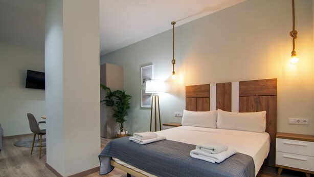 A modern hotel room with a large bed, bedside tables, a desk, and a TV. - VLC HOST - Reino 5 (Valencia)