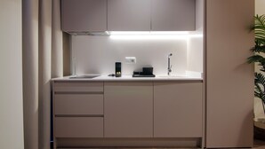 A modern kitchen with a white countertop, a sink, a coffee machine, and cabinets. - VLC HOST - Reino 5 (Valencia)