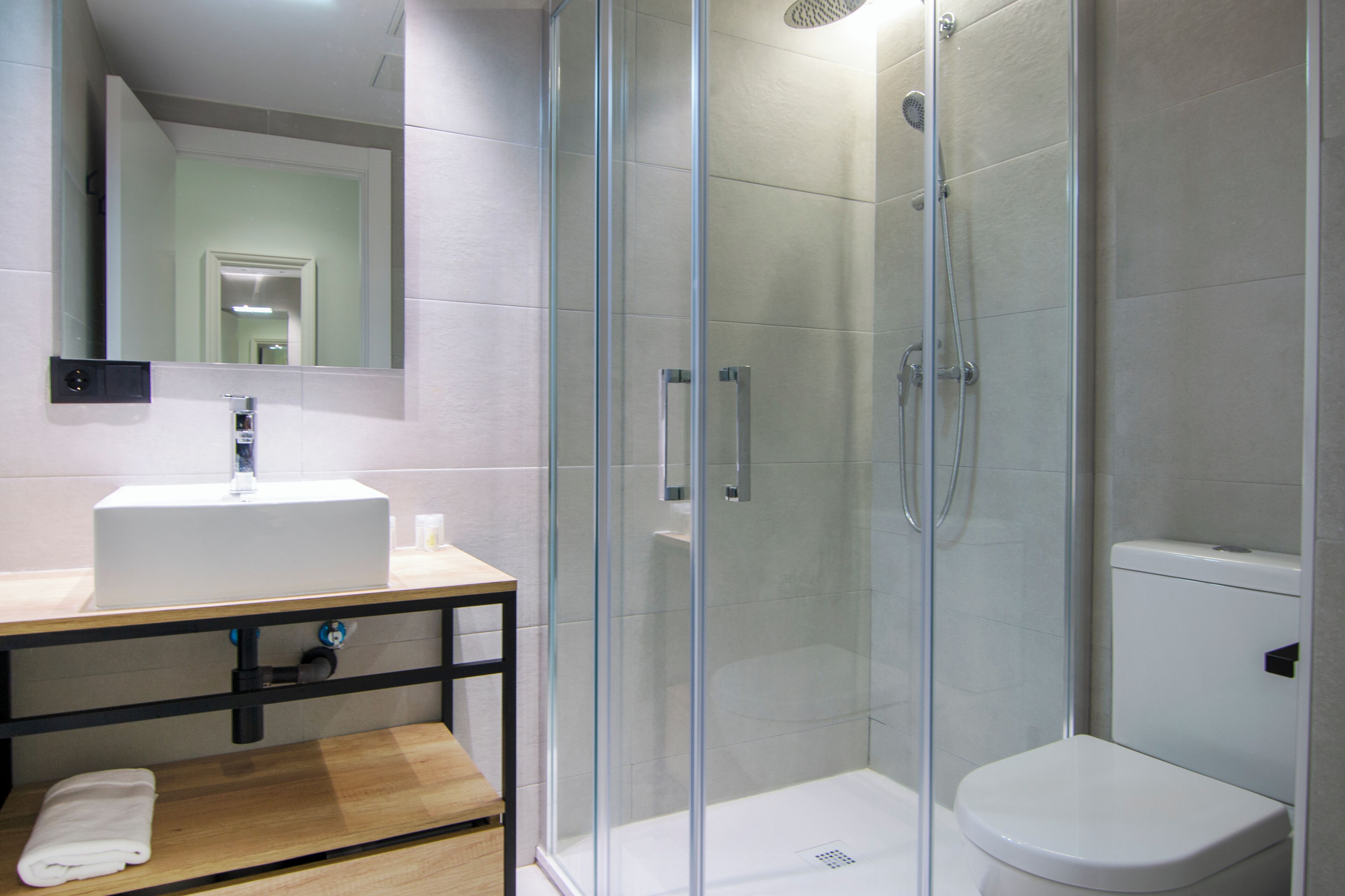 Une salle de bain moderne avec une douche à parois de verre, un lavabo blanc et des toilettes.