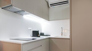 Una cocina moderna con armarios blancos, estufa integrada y un lavamanos.
