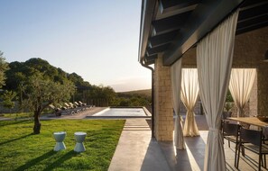 Un espace piscine comprenant des chaises longues, une pergola et un coin repas avec une table et des chaises.