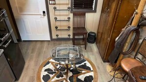 Una cocina con una mesa redonda, un armario de madera y una puerta con barras para toallas.