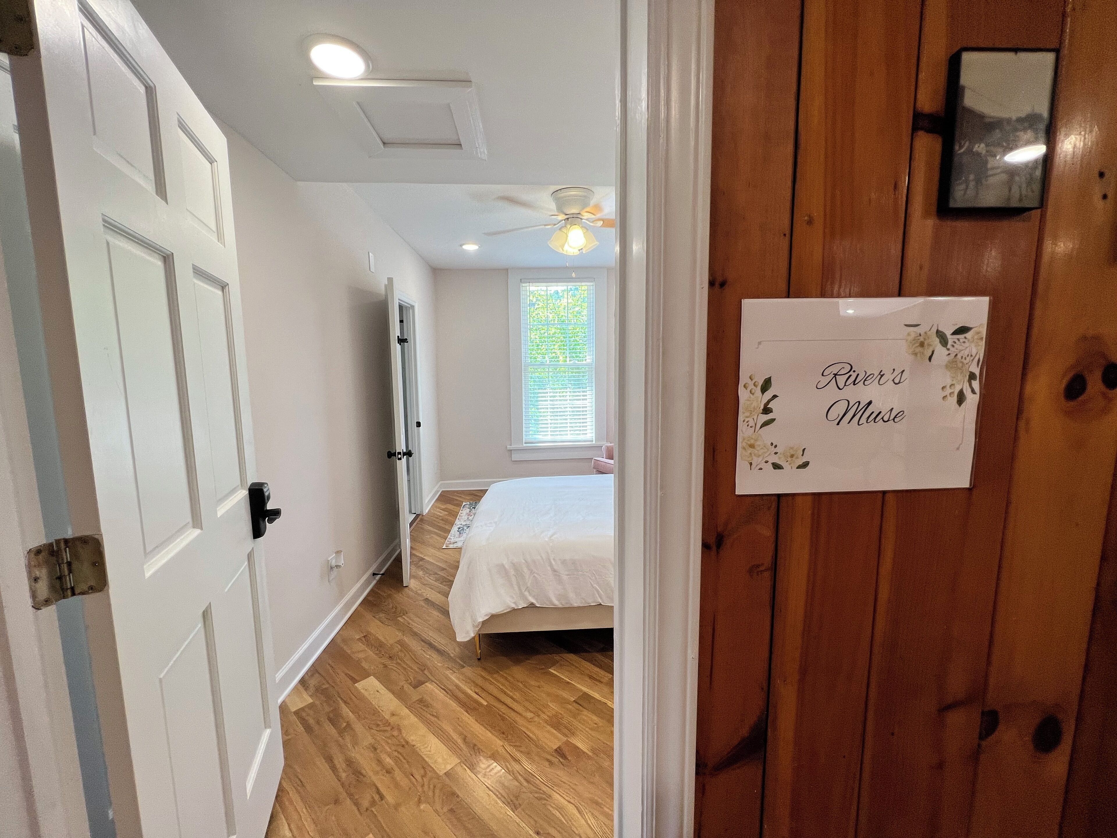 Quarto com cama, ventilador de teto e janela com persianas.
