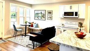 A modern kitchen with white cabinets, a marble countertop, and a built-in oven. - Entire cozy Rollingstone apt in Mississippi Valley, just 10 min from Winona! (Rollingstone)