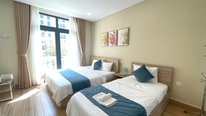 Une chambre d’hôtel avec deux lits, un bureau et une fenêtre avec des rideaux.