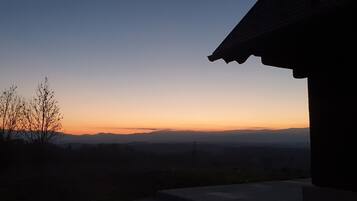 A sunset view from a building with a roof visible on the right.