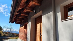 A building with a wooden facade, a concrete entrance, and a view of the outdoors.