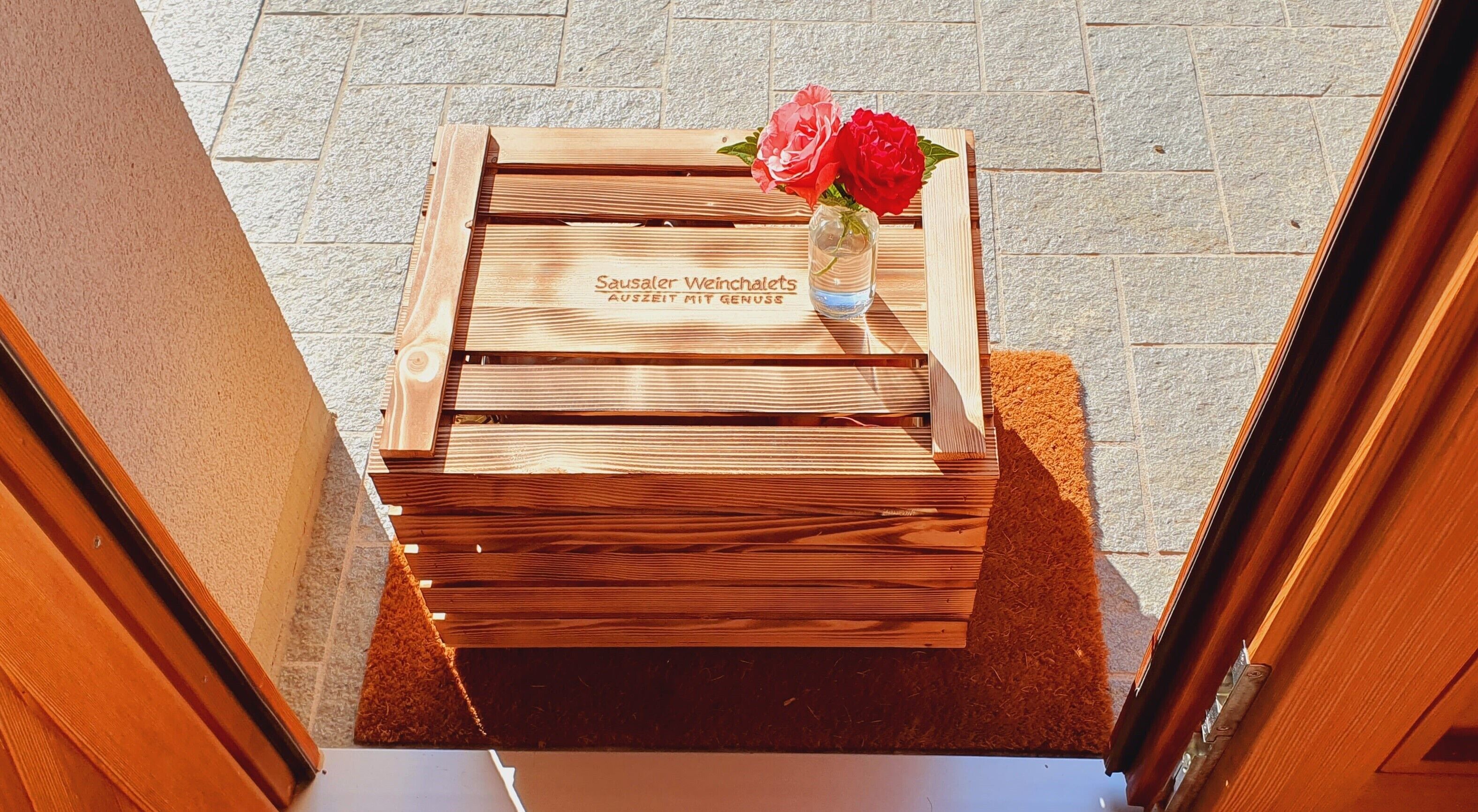 Un banco de madera con una placa y un jarrón de flores.