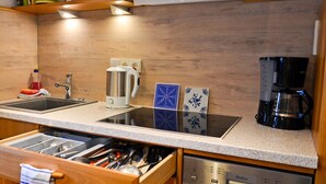 A kitchen with a granite countertop, stainless steel appliances, and a wooden backsplash.