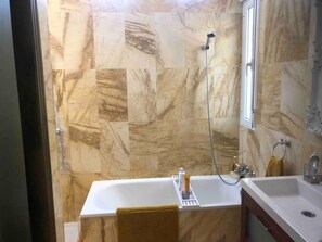 Een bad/douchecombinatie, handdoeken