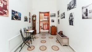 A hallway with a dining area, photographs on the walls, a clock, and a cabinet. - Holiday Home 'Rachele' with Mountain View, Wi-Fi and Air Conditioning (Dorgali)