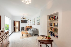 Un vaste espace de vie comprenant une cheminée, un canapé, une table basse et une bibliothèque.