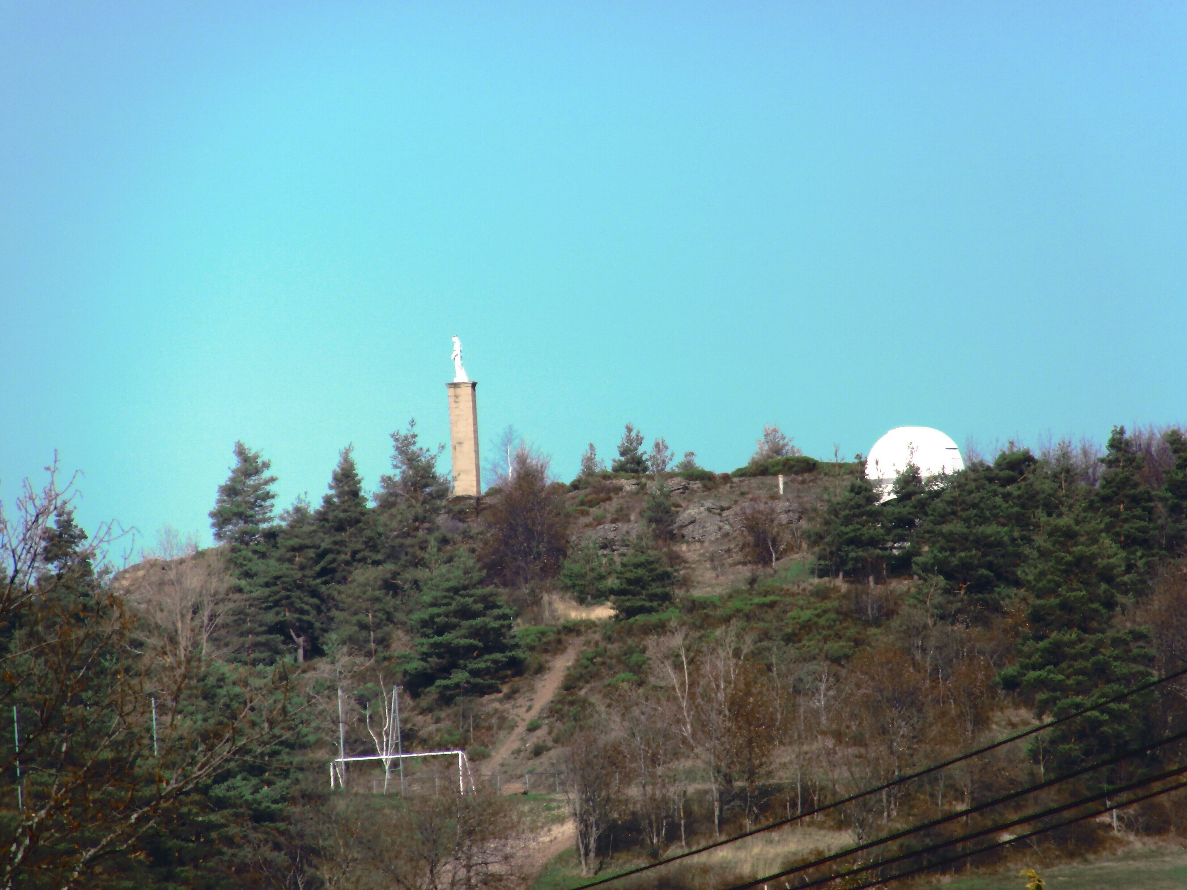 Une colline surmontée d’un monument et d’une structure en forme de dôme.