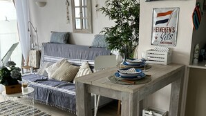 Ein gemütliches Wohnzimmer mit einem Holztisch, einer Couch und einem Esstisch.