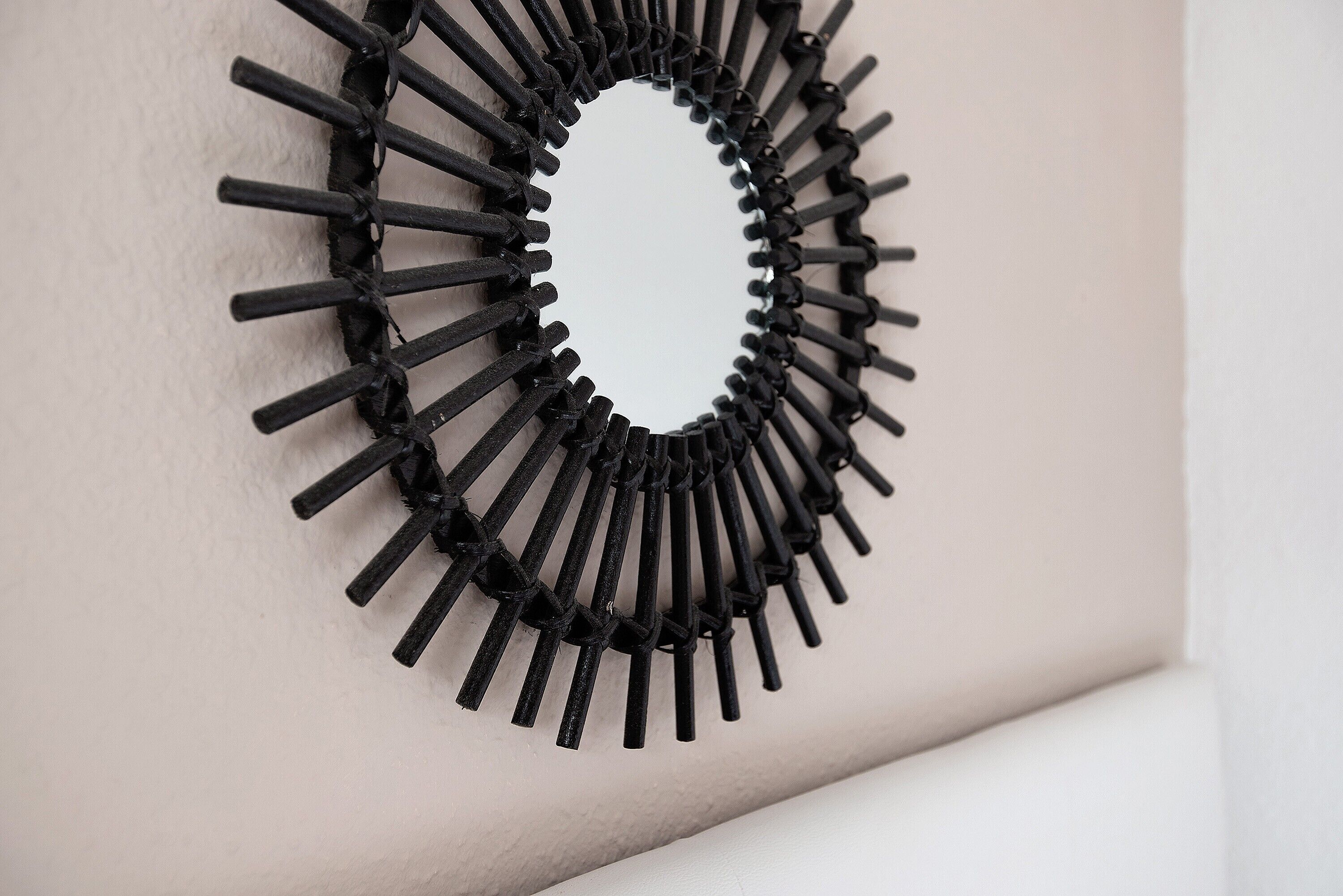 Un oggetto circolare nero, con texture e una cavità centrale, fissato alla parete.