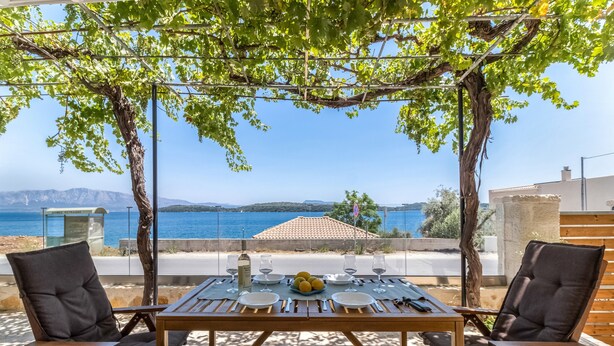 Ein Tisch für zwei Personen mit Blick auf das Meer und die Berge.