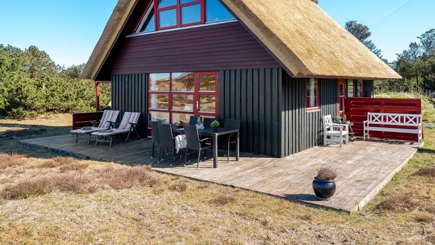 A thatched-roof cabin with a deck, outdoor seating, and a large window. - "Larsen" - 900m from the sea by Interhome (Fanø)