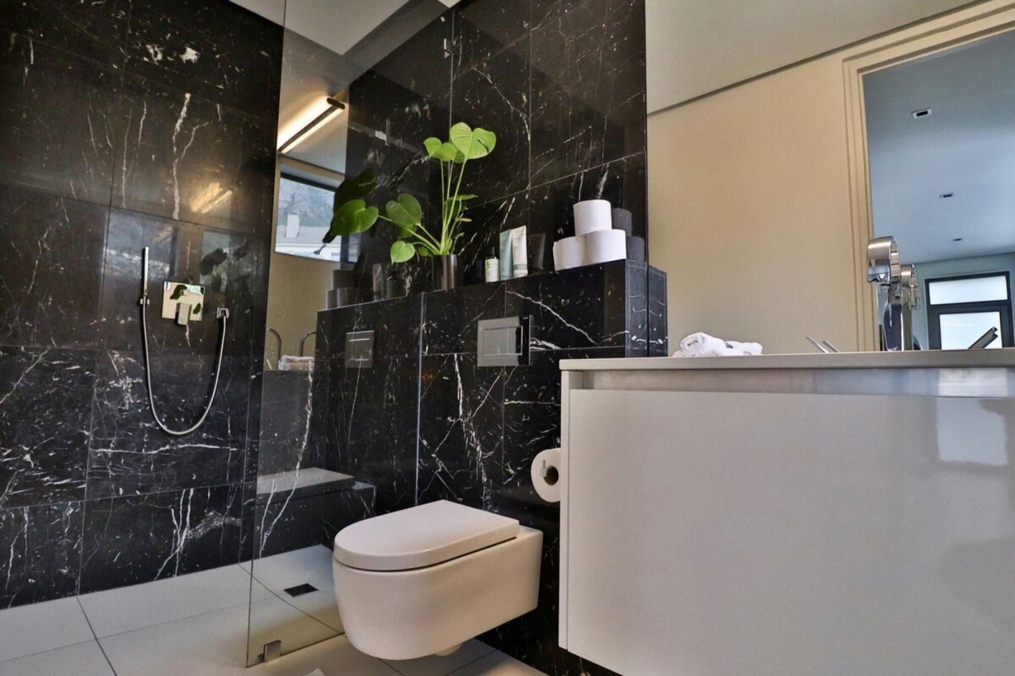 Un baño moderno con inodoro, ducha y lavamanos.