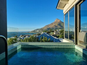 A swimming pool with a clear view of a mountain and a coastal town in the background. - Amara 2 -designer Penthouse With Spectacular Views (Cape Town)
